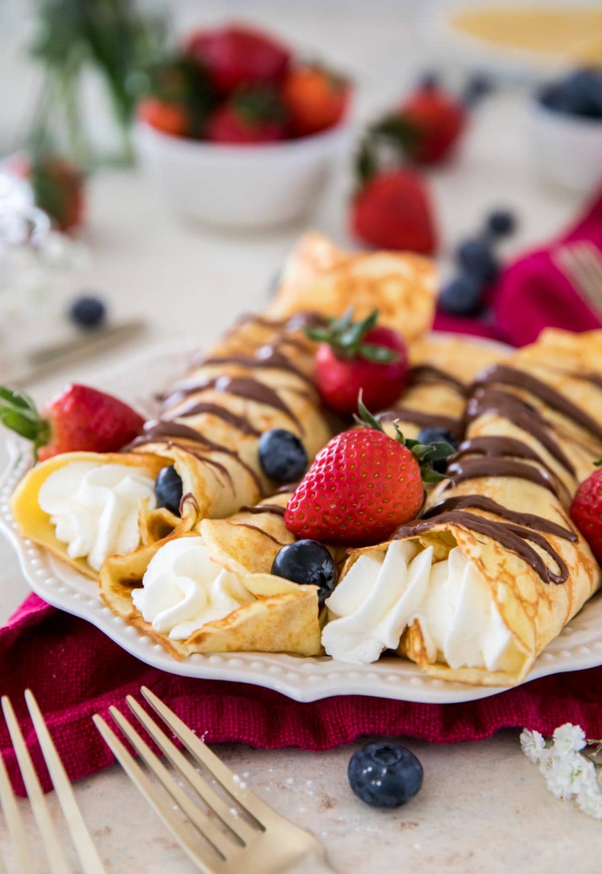 Crepes filled with whipped cream, drizzled with nutella and topped with berries
