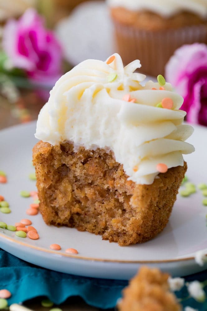 Half of a carrot cake cupcake, showing the moist vibrant orange center