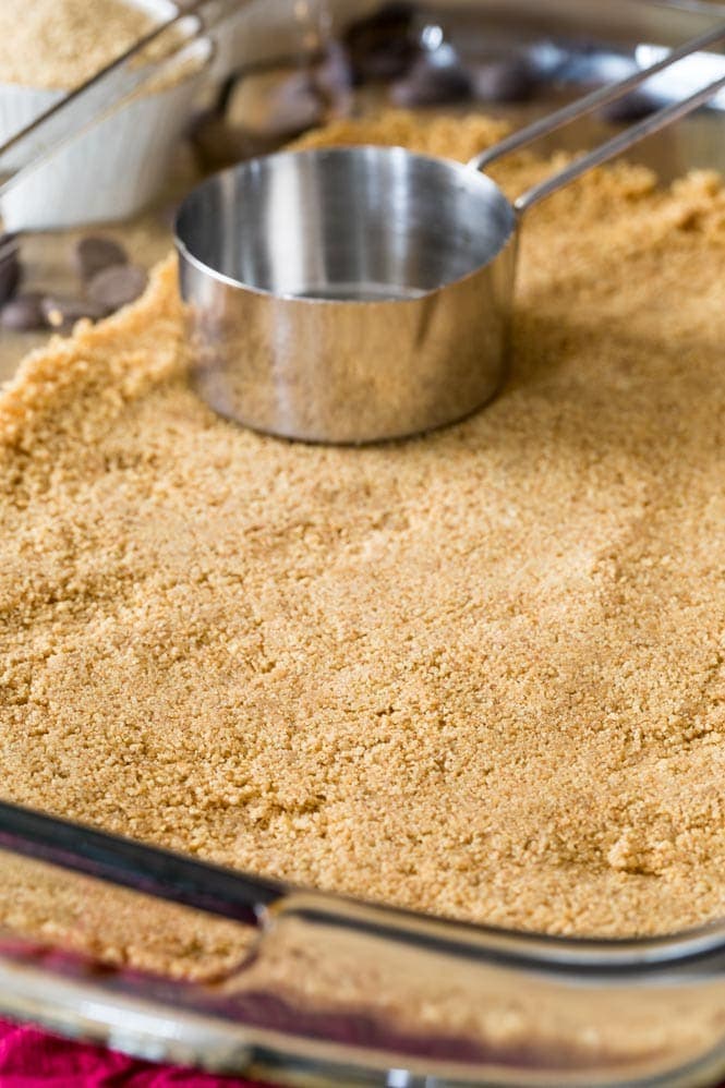 Showing how to make a graham cracker crust for Magic Cookie Bars