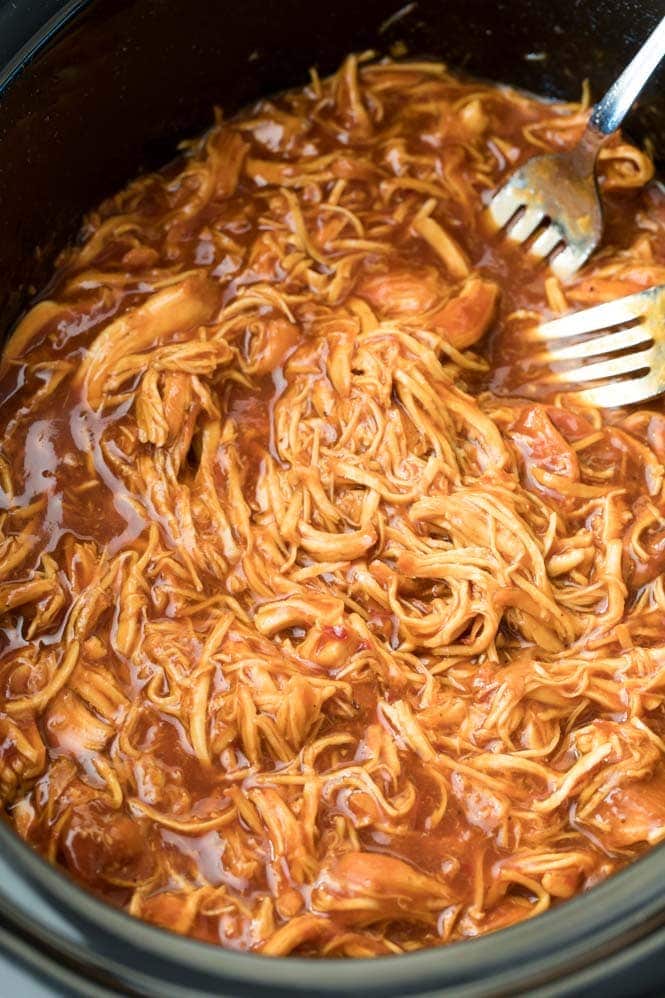 Pulled chicken in the basin of a slow cooker