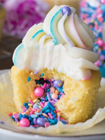Piñata cupcake: topped with vanilla frosting, sprinkles pouring out of center