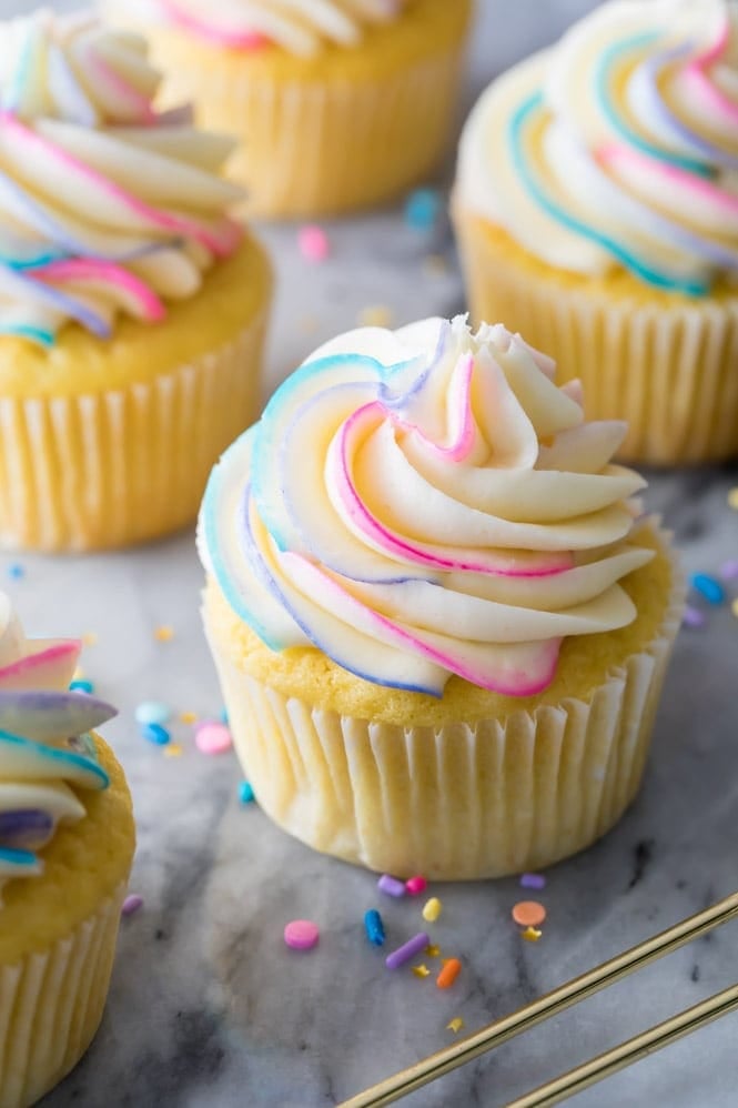 Vanilla frosting piped onto a cupcake with colorful swirls