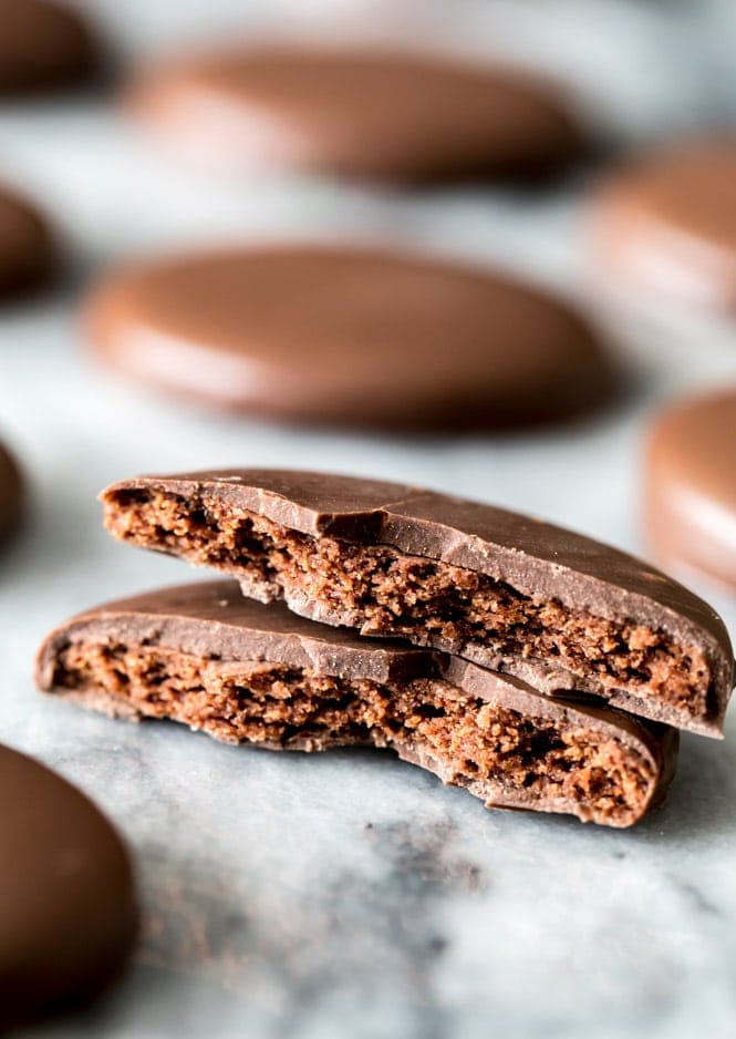 A thin chocolate wafer cookie coated in chocolate, broken in half to showcase the crisp center and chocolate cloak