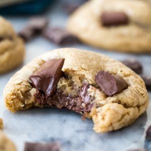 Chocolate chip cookie with bite missing showing melted gooey chocolate