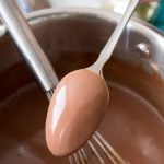 Chocolate pudding batter on spoon over saucepan