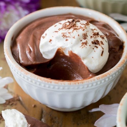 Chocolate pudding topped with whipped cream in bowl