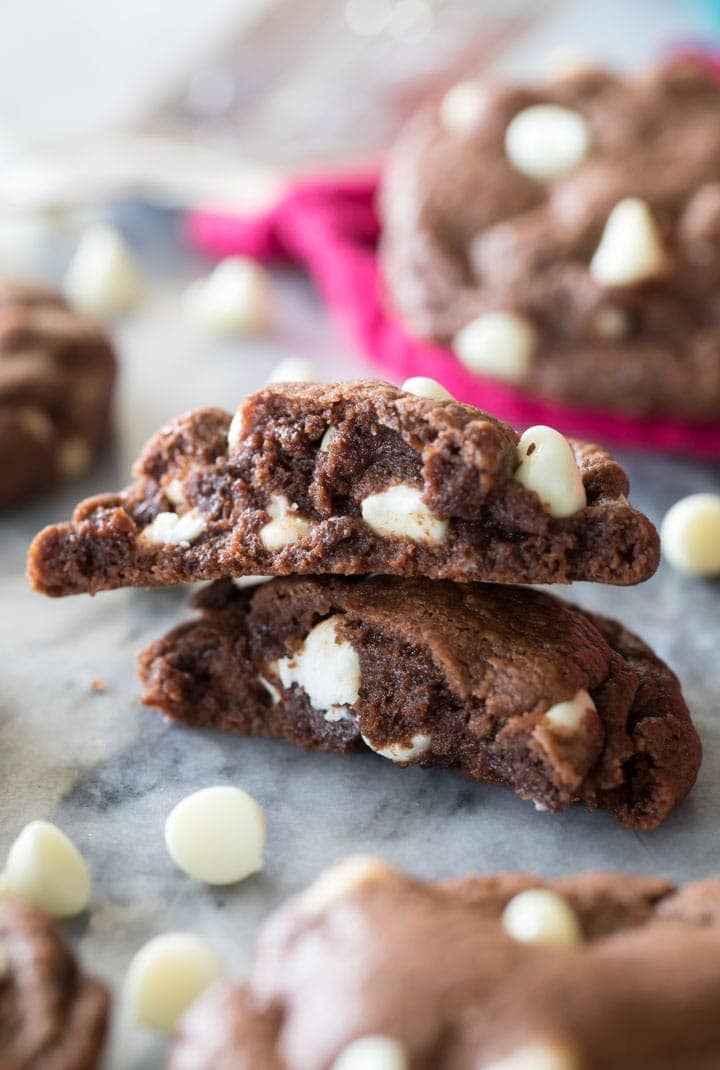 Two stacked halves of a chocolate cookie studded with white chocolate chips.