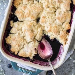 freshly baked cobbler with spoon in blueberry juices
