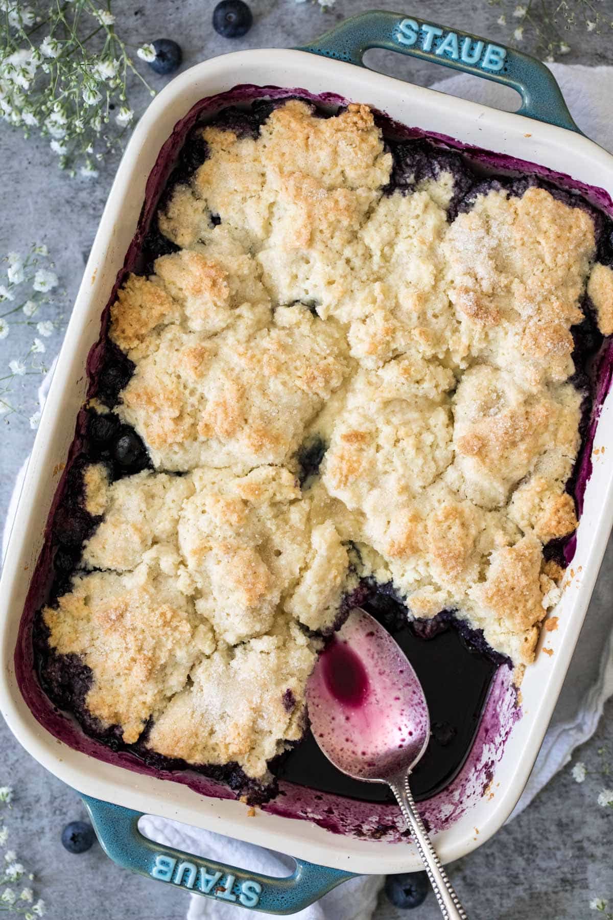freshly baked cobbler with spoon in blueberry juices