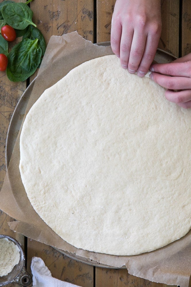 Folding over pizza dough to form a crust 