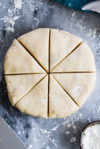 Scone dough shaped into disc, cut into 8 pieces