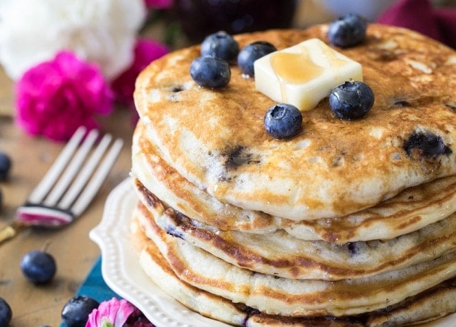 Blueberry pancakes topped with fresh berries and butter