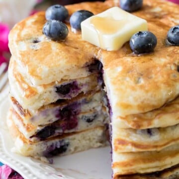 Stack of blueberry pancakes topped with pat of butter