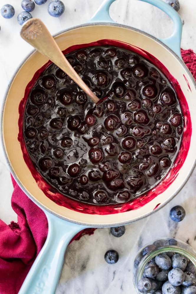 Cooking blueberries in a pot to make blueberry sauce