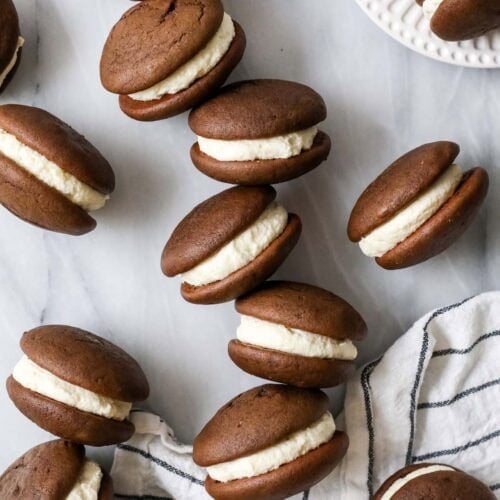 Scattered whoopie pies sitting on their sides to show their creamy filling.