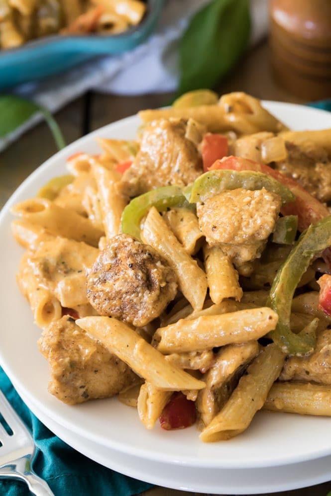 Cajun chicken with penne pasta served on white plate