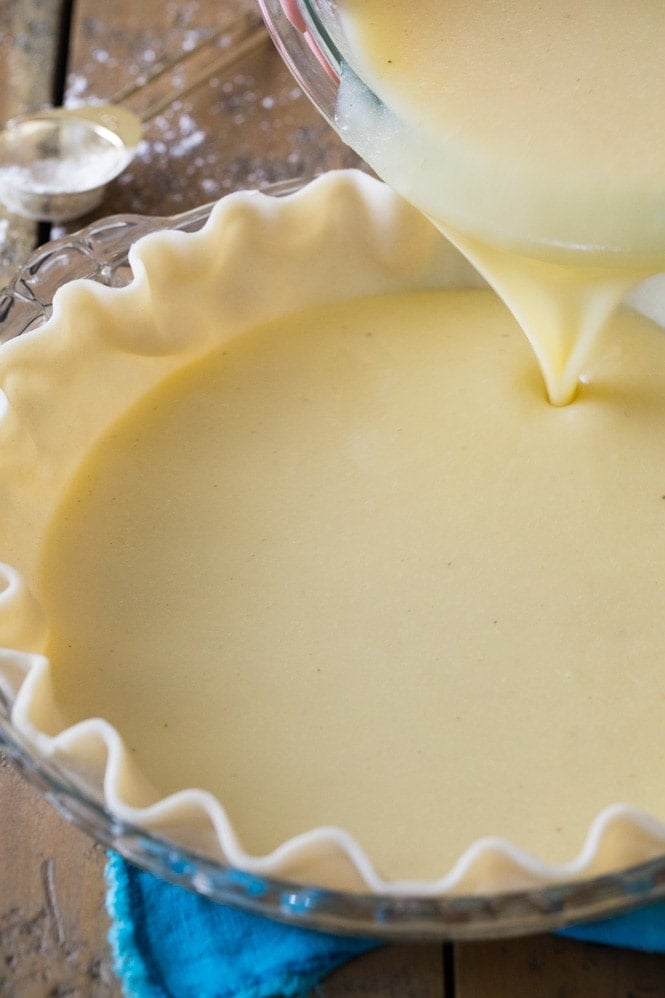 Pouring buttermilk pie filling into pie shell