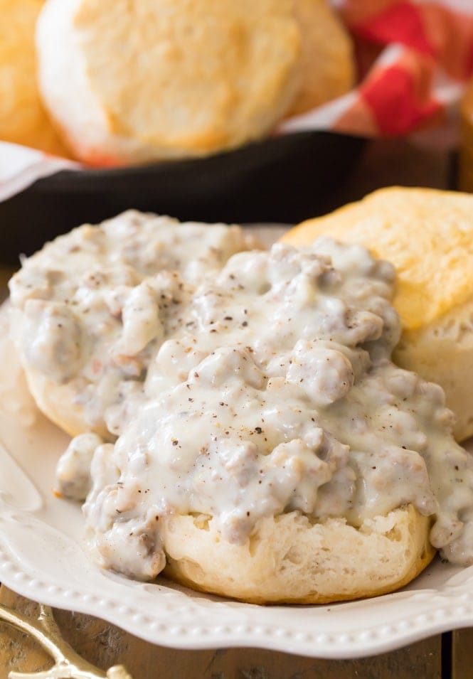 homemade biscuits covered with sausage gravy on white plate