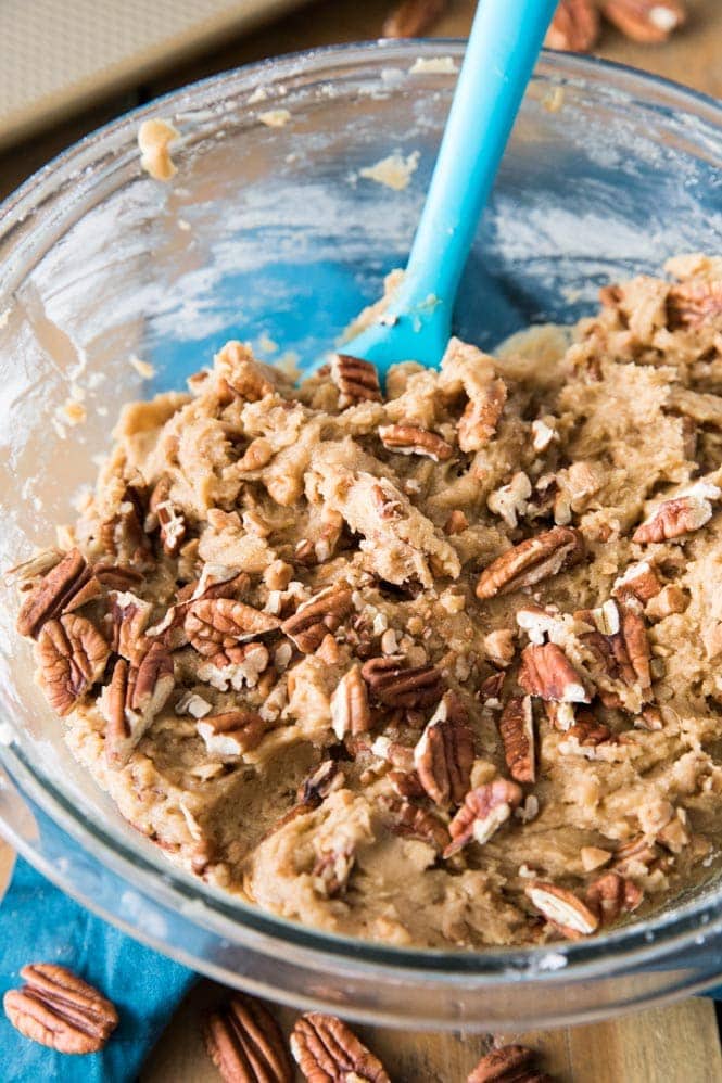 How to make butter pecan cookies: stirring nuts and toffee into cookie dough