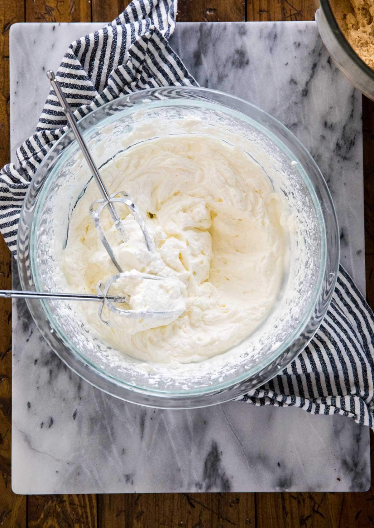 whipped cream with beaters in glass bowl