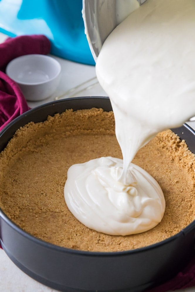 How to make cheesecake: pouring creamy cheesecake batter into graham cracker crust