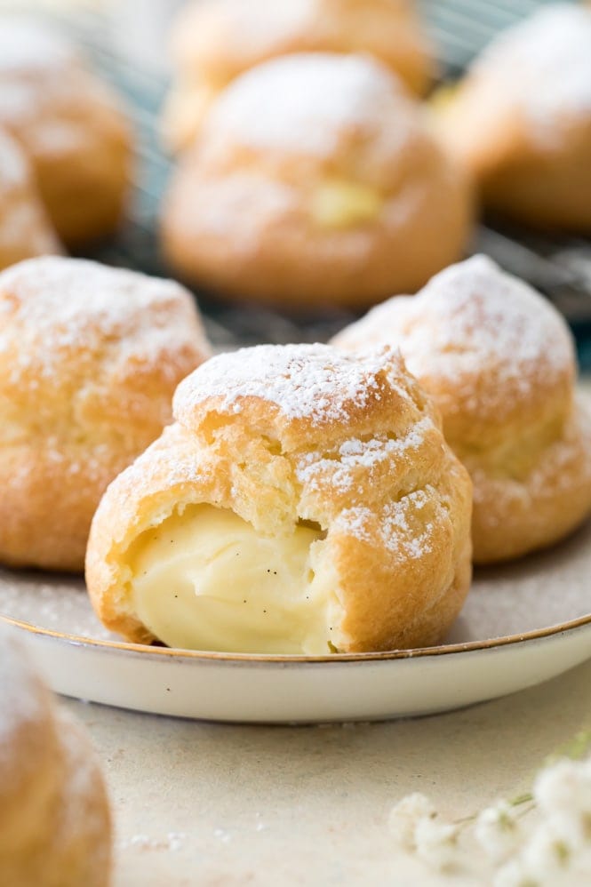 Inside of a cream puff; sugar dusted choux pastry filled with pastry cream