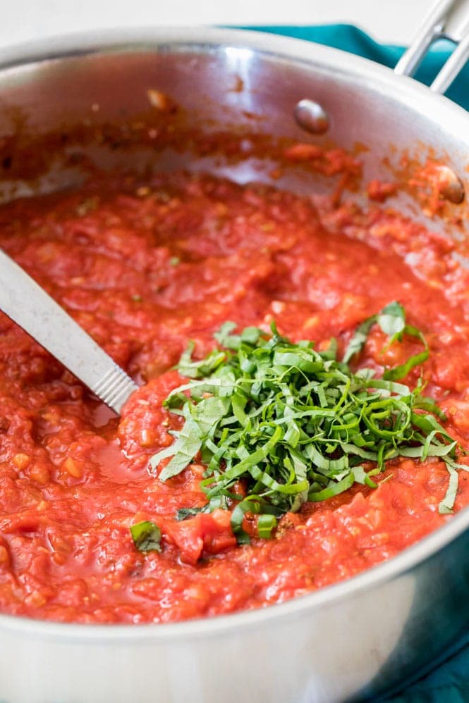 How to make Marinara Sauce from scratch: Stirring basil into simmering sauce