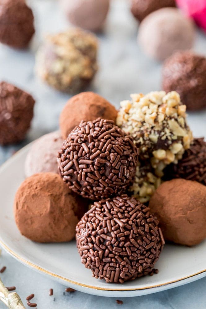 an assortment of chocolate truffles on a white plate