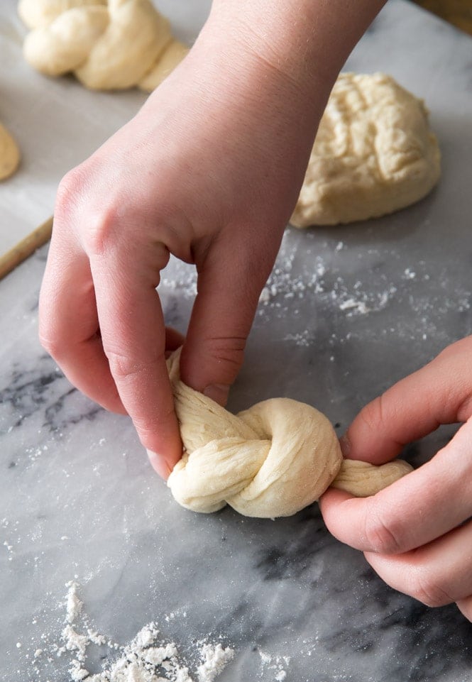Tying dough rope into knot for garlic knots
