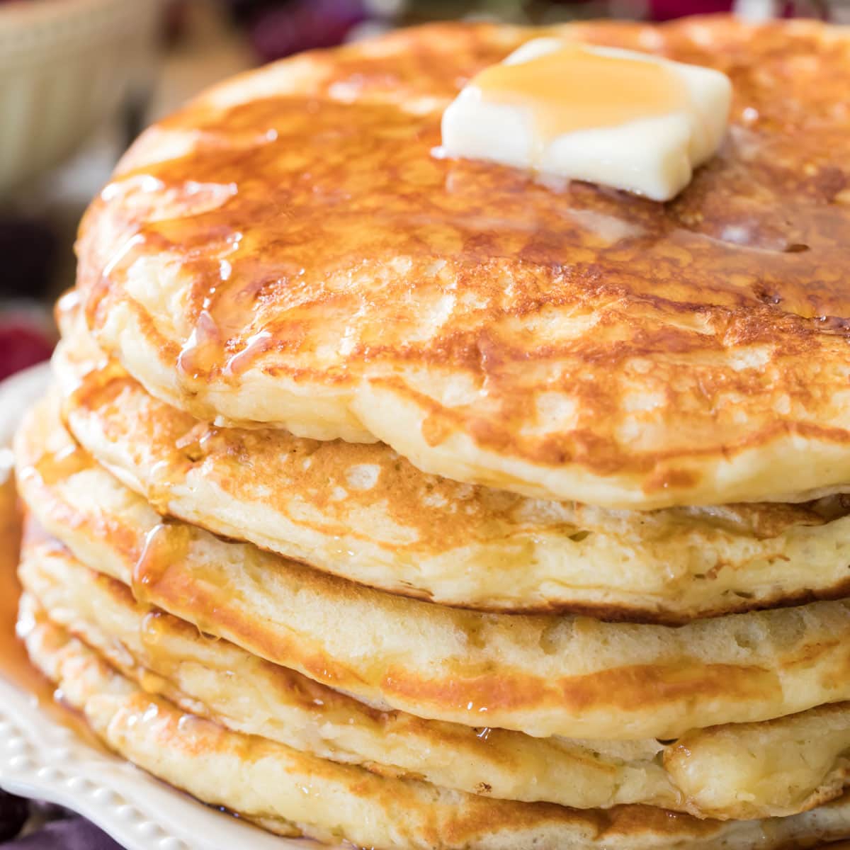buttermilk pancakes on white plate with butter
