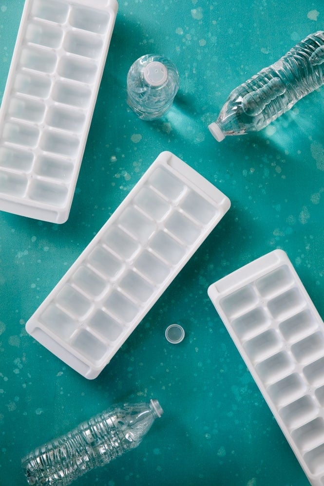 Overhead view of ice cube trays and water bottles