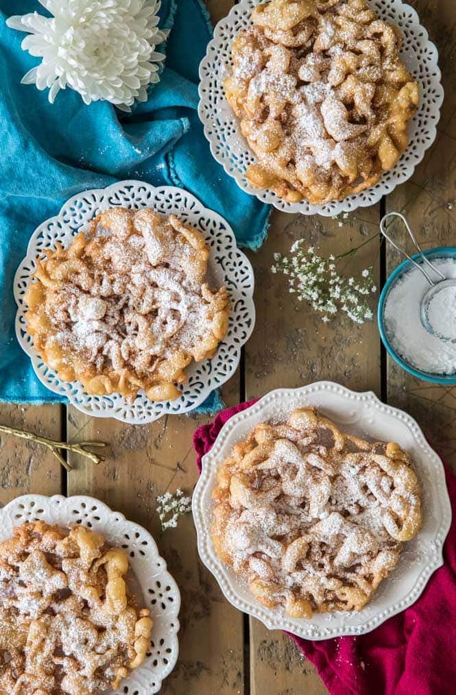 4 funnel cakes dusted with powdered sugar