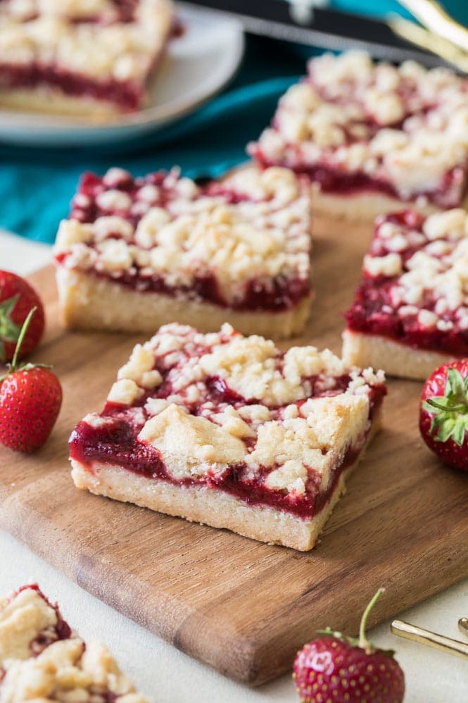 Strawberry crumb bars on wood cutting board