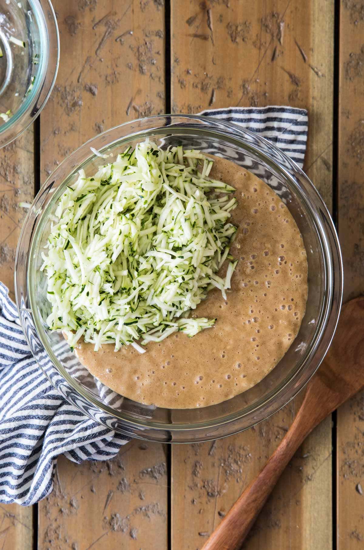 batter with shredded zucchini in glass bowl