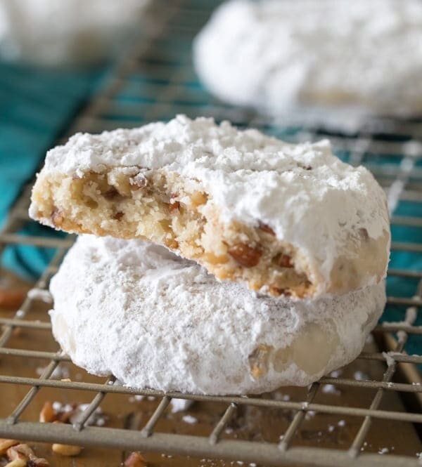 Pecan sandies stacked on top of each other on wire cooling rack with bite taken out.