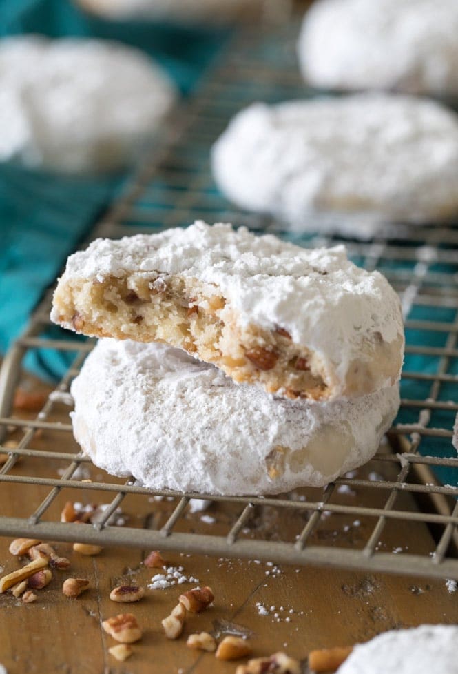 Two pecan sandies on cooling rack, one showing buttery interior