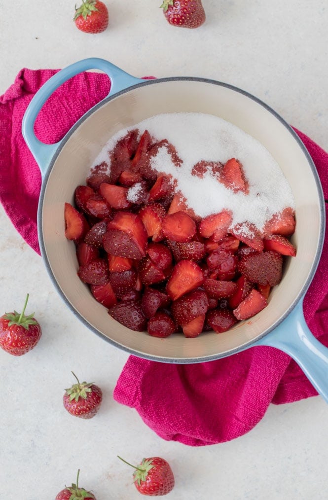 Quartered strawberries in a saucepan with sugar