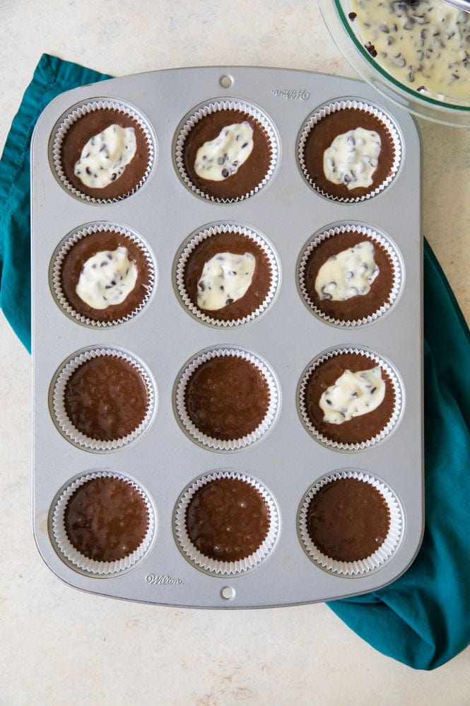 Adding cheesecake batter on top of cupcake batter to make black bottoms