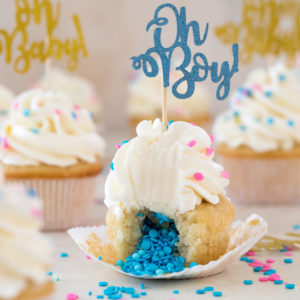 Cupcake broken open to reveal insides topped with frosting and "oh Boy!" decoration