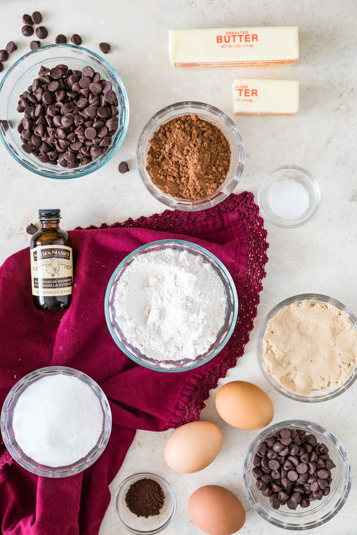 Overhead of ingredients for brownies arranged on a light-colored backdrop