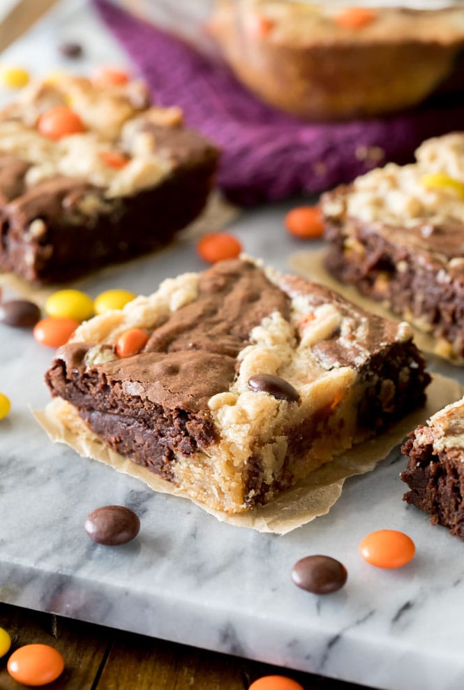 Peanut butter brownie square on marble board surrounded by candy pieces