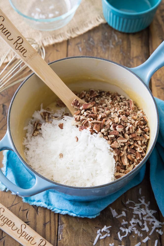 Making German Chocolate Cake Frosting in saucepan with coconut and pecans