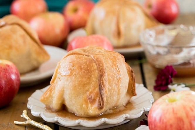 Apple dumpling topped with syrup on white plate