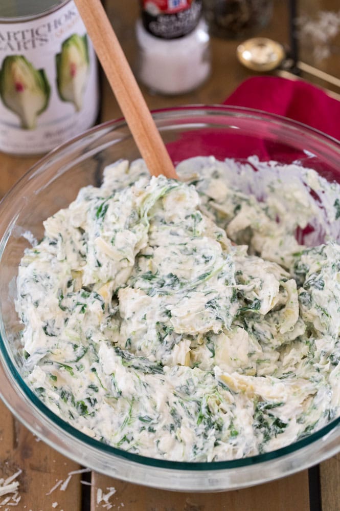 Spinach artichoke dip ingredients mixed together in bowl