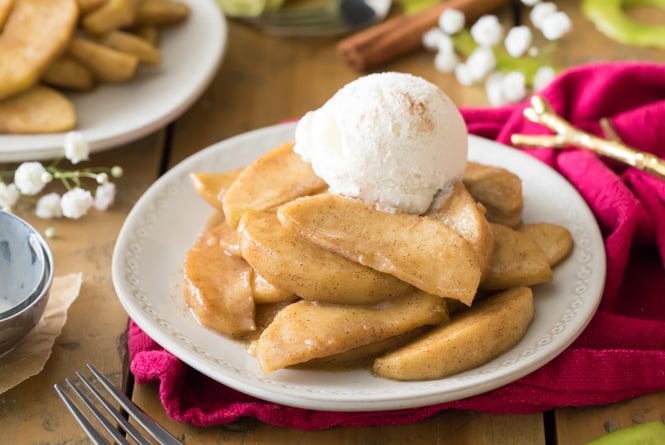 Fried apples on white plate with ice cream on top