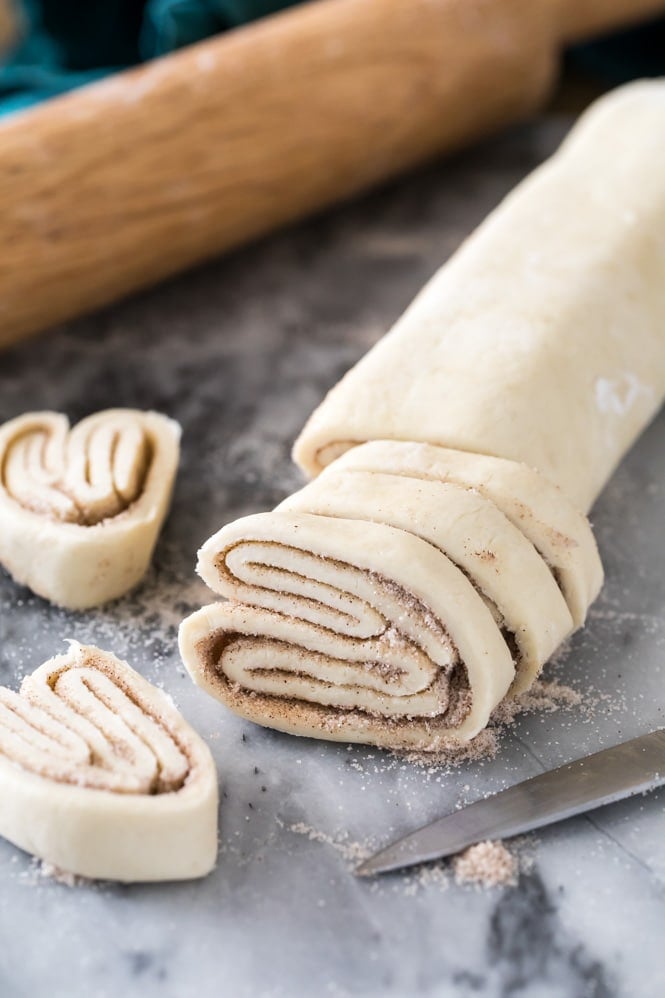 Using a sharp knife to slice cinnamon palmier dough