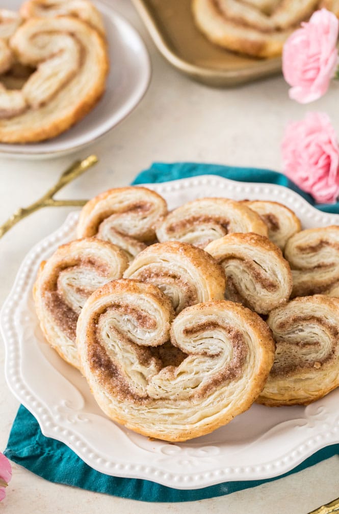 Palmiers on a white plate, showcasing cinnamon/sugar ripple and flakey buttery layers