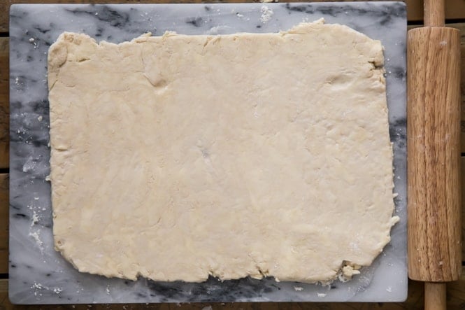 Rolling out puff pastry dough into 8x12 rectangle