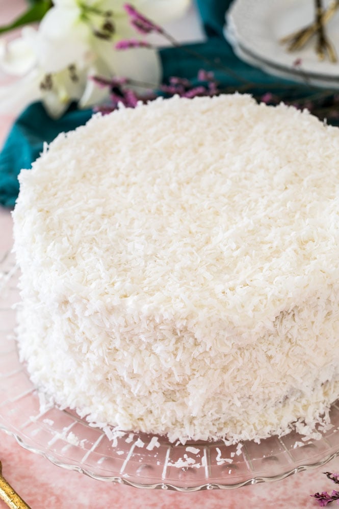 Frosted and coconut-covered coconut cake on crystal platter