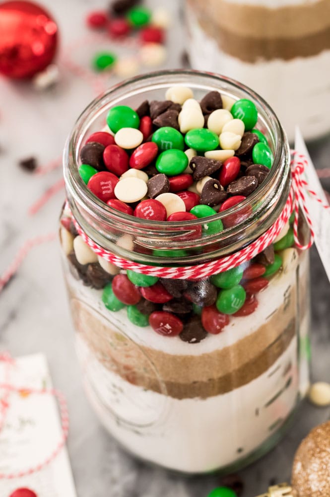 Mason jar of cookie mixed topped off with chocolate chips and M&Ms